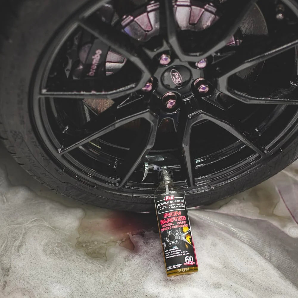 Iron remover spray bottle on a wheel surface with light, foamy residue