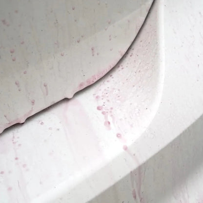 Painted surface with scattered red-brown specks and light foamy residue