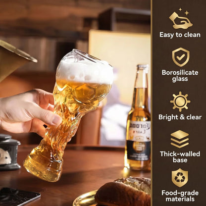 Crystal beer trophy glass held in hand, clear rim and thick base, amber liquid inside
