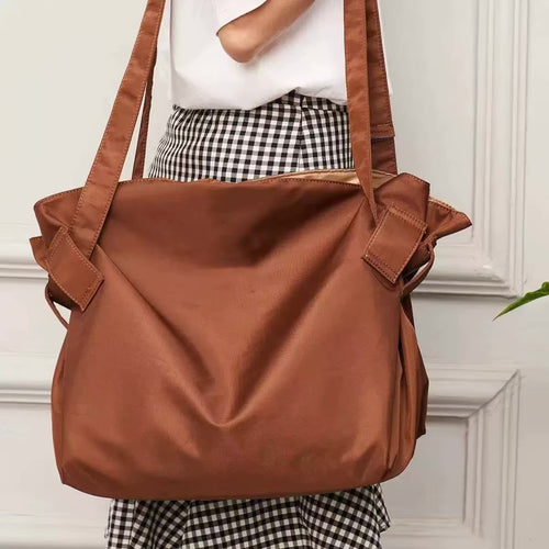 Brown foldable travel organizer bag with side handles and front flap closure
