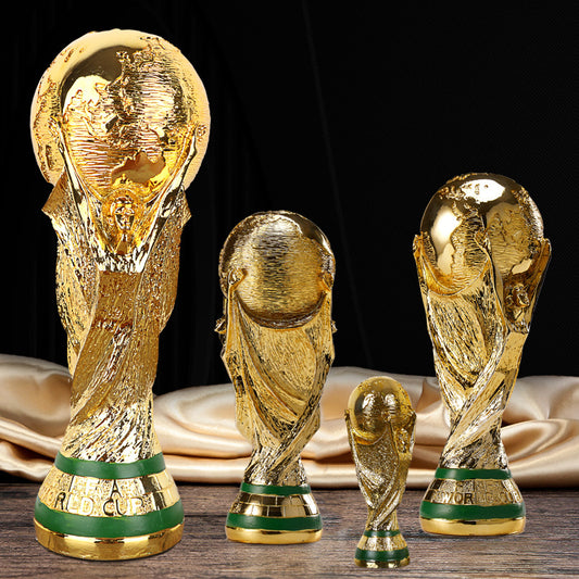 Gold football trophy replica set with green-banded bases, three cups and a small trophy